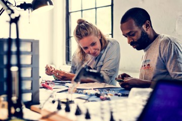 zwei Menschen reparieren elektronische Geräte