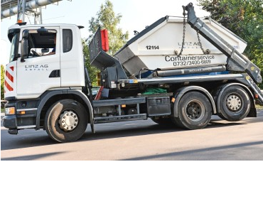 Ein Lastkraftwagen hat einen Abfallcontainer für den Containerverleih von LINZ AG ABFALL aufgeladen.