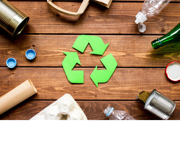 Recycling logo umgeben von etwaigen Abfällen.
