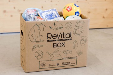 Papierschachtel mit der Aufschrift ReVital Box, befüllt mit verschiedenen Utensilien
