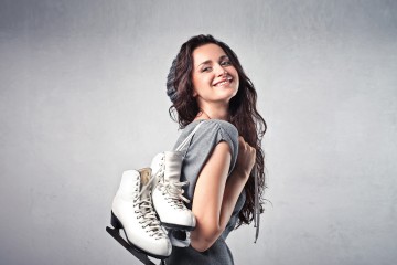 Frau, die Eislaufschuhe über die Schultern trägt