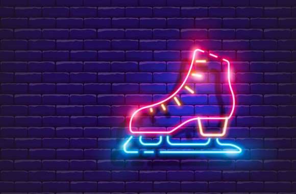 Im Bild zu sehen ist ein Eislaufschuh, der mit Neonfarben beleuchtet ist.