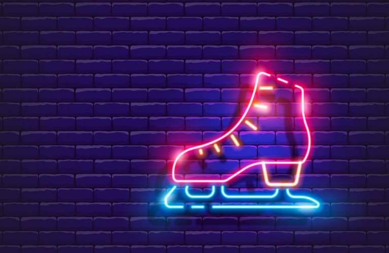 Im Bild zu sehen ist ein Eislaufschuh, der mit Neonfarben beleuchtet ist.