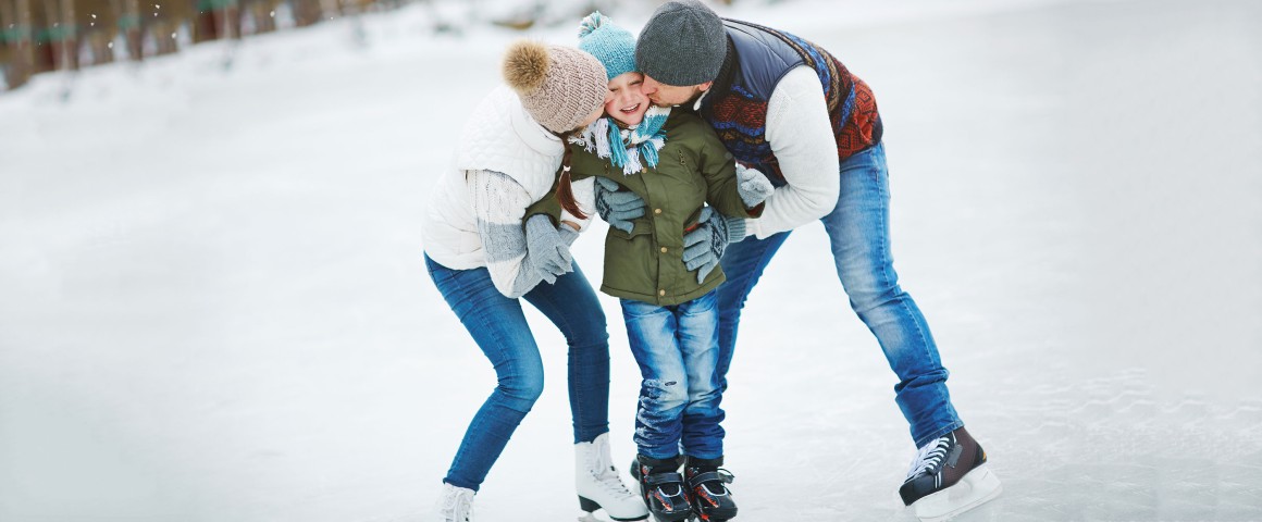 Eltern mit Kind beim Eislaufen