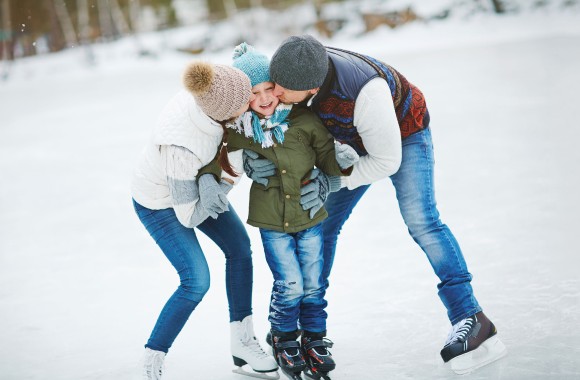 Eltern mit Kind beim Eislaufen