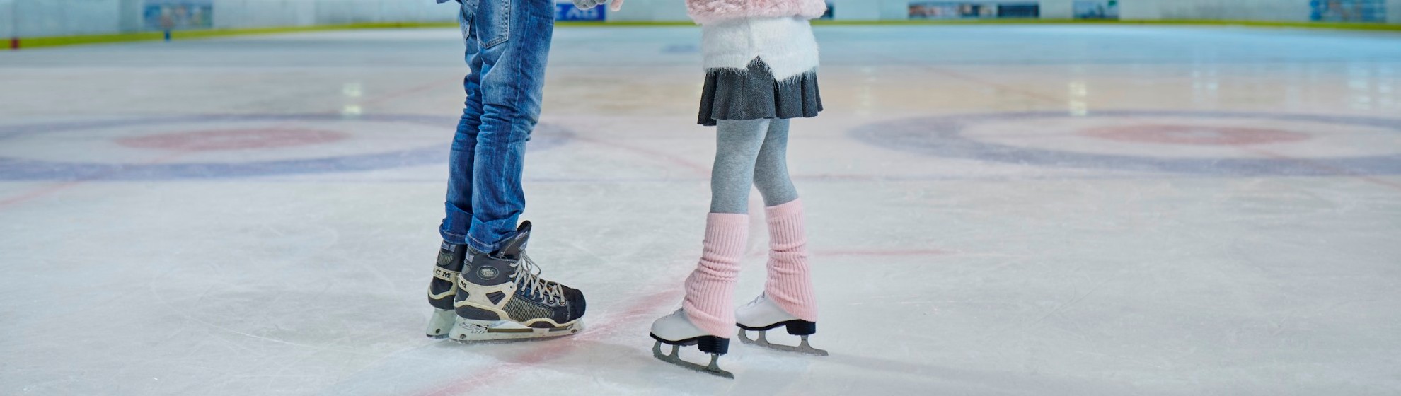 Sohn und Tochter stehen am Eis und halten sich an den Händen