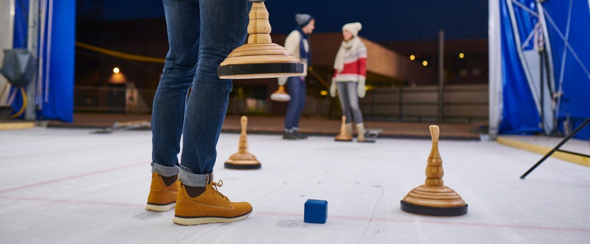 Mann von Hinten Lende abwärts beim Eisstockschießen