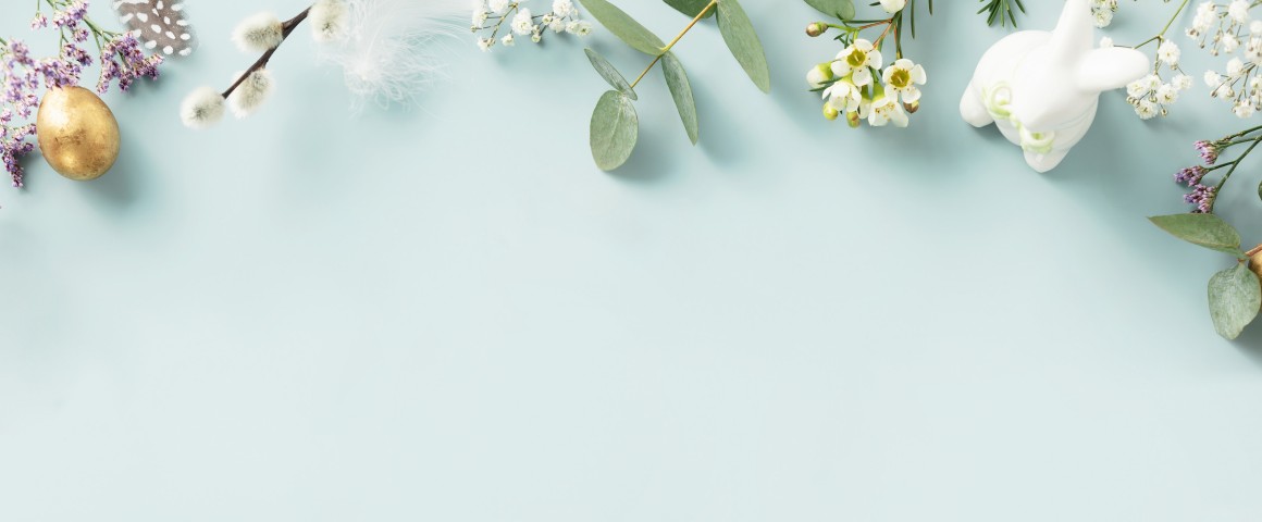 Osterhase, Eier, Blumen, Blüten und Palmkätzchen auf blauem Hintergrund
