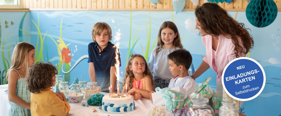 Bild von einem Kindergeburtstag. 6 Kinder (3 Jungen und 3 Mädchen) mit einer Mutter sind um einen Tisch versammelt. Auf dem Tisch befinden sich Süßigkeiten und eine Torte mit einer Spritzkerze darauf. Rechts in der Ecke ist ein Banner mit der Aufschrift "Neu Einladungskarten zum Selbstdrucken".