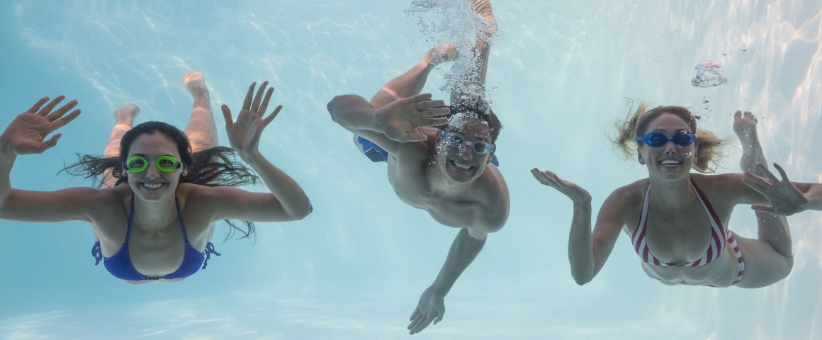 Drei Personen tauchen im Pool unter