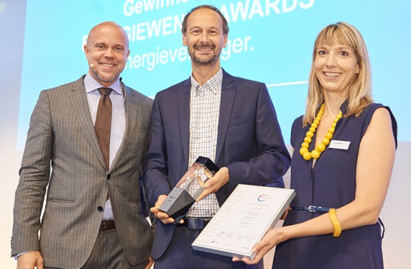 Drei Leute (zwei Männer und eine Frau) halten lächelnd den Energieaward 2018 in der Hand.