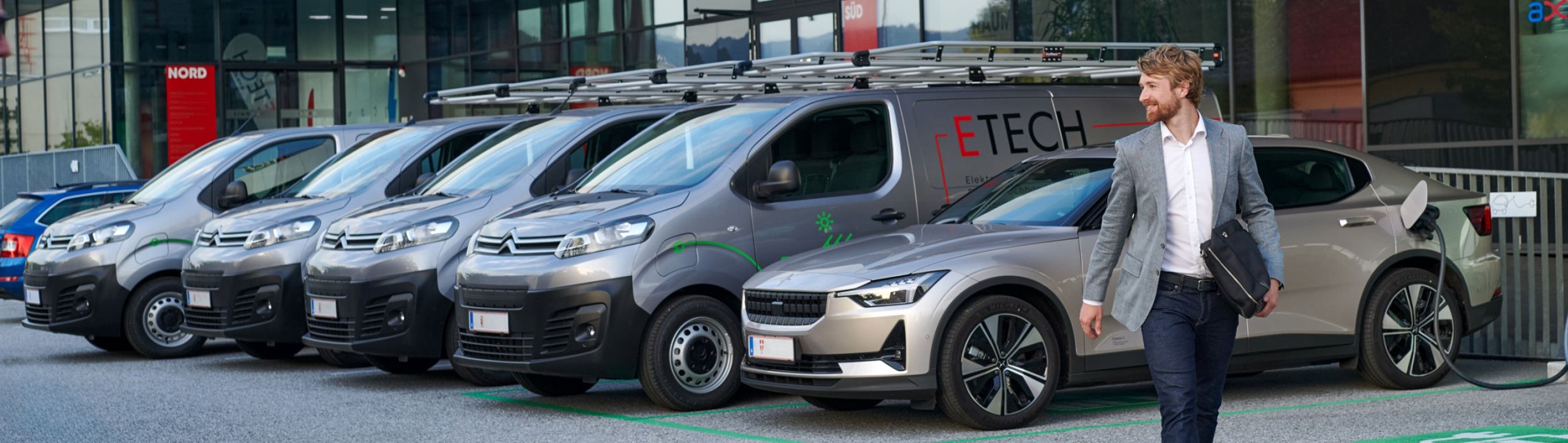 Mann im grauen Sakko vor Geschäftspassage.