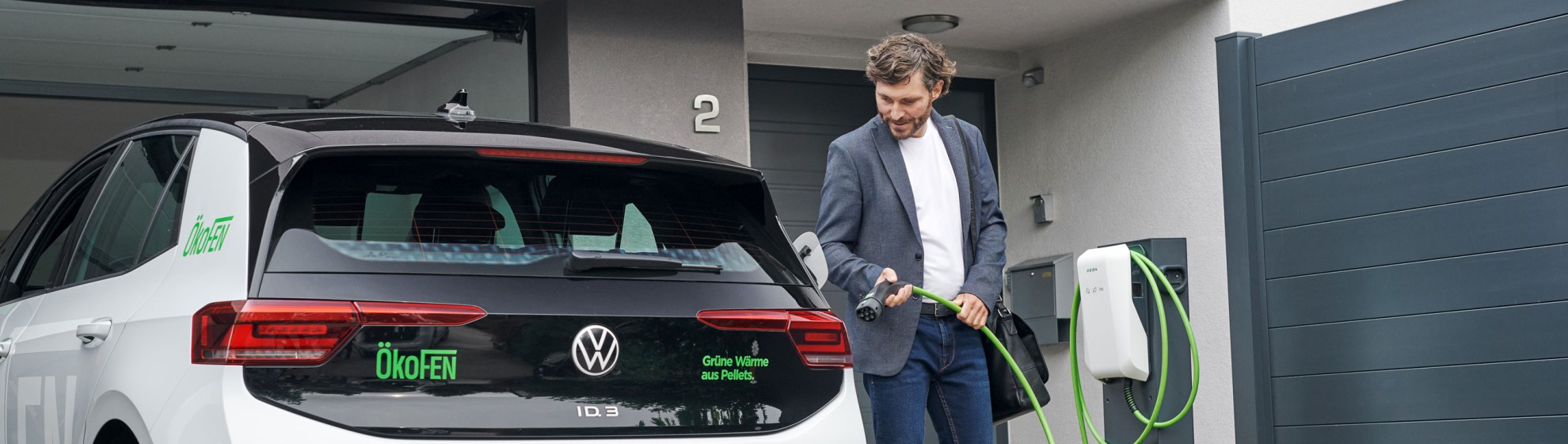 Herr im Anzug lädt sein Auto in der privaten Garage.