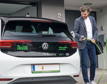 Herr im Anzug lädt sein Auto in der privaten Garage.