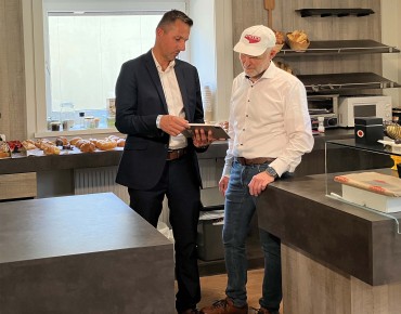 Thomas Priglinger hält ein Tablet in der Hand und ist im Gespräch mit Reinhard Honeder in einer Honeder-Filiale