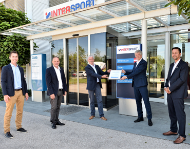 Geschäftsführer der Intersport GmbH und der LINZ-ENERGIESERVICE GmbH stehen vor der Intersport-Zentrale zum offiziellen Abschluss des gemeinsam umgesetzten Klimaschutzprojekts.