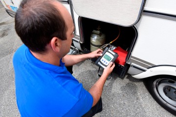 Ein LINZ AG-Techniker wartet die Flüßiggasanlage eines Wohnmobils.