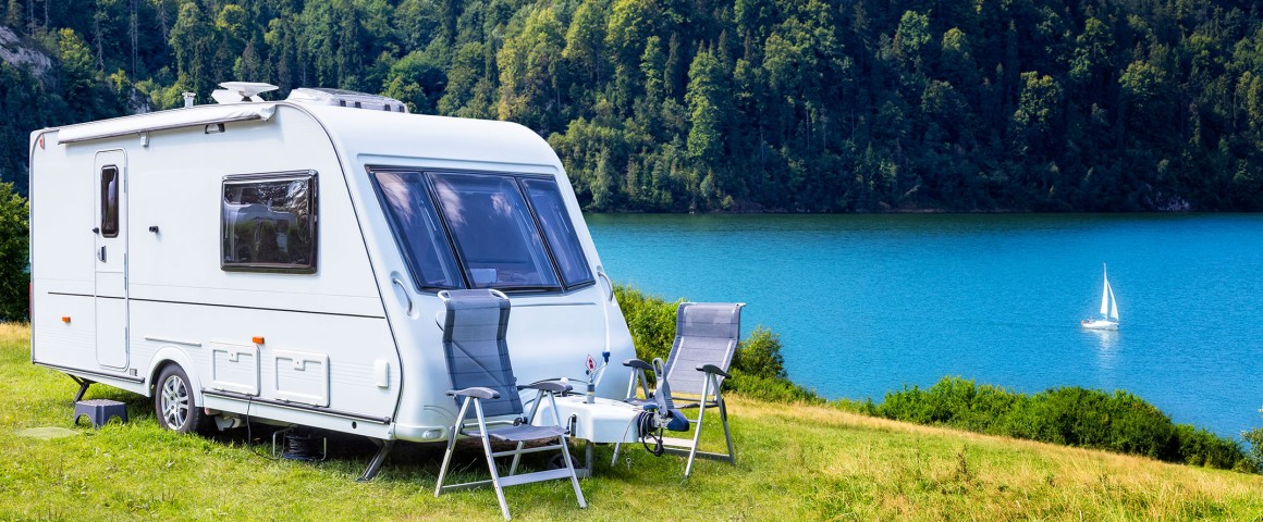 Wohnwagen am  See mit  Berg im Hintergrund