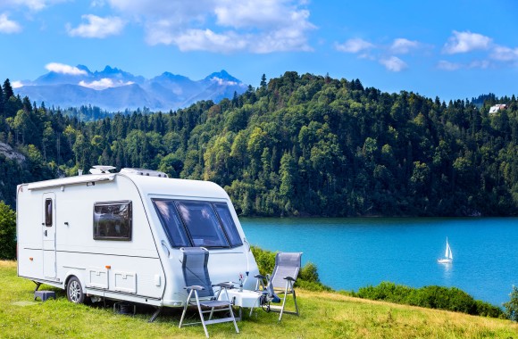 Wohnwagen am  See mit  Berg im Hintergrund