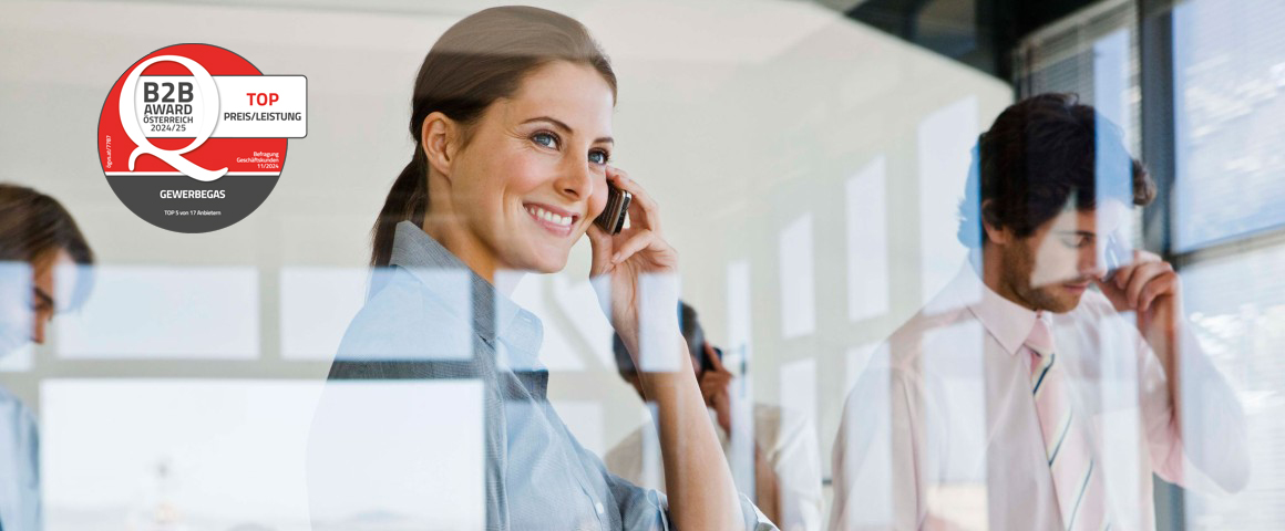 Blick durch eine Fensterscheibe auf eine telefonierende Businessdame.