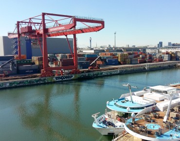 Überblick über Hafen mit Schiffen, Containern und Kränen