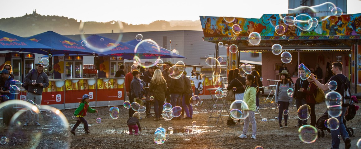 Impressionen von den Ständen am Hafenfest: Plaudernde Menschen, spielende Kinder und Seifenblasen