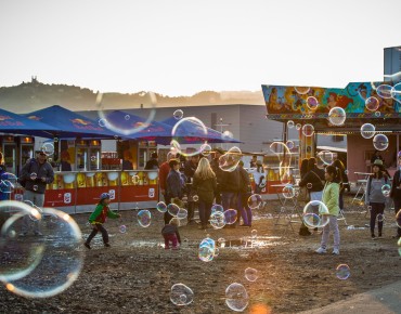 Impressionen von den Ständen am Hafenfest: Plaudernde Menschen, spielende Kinder und Seifenblasen