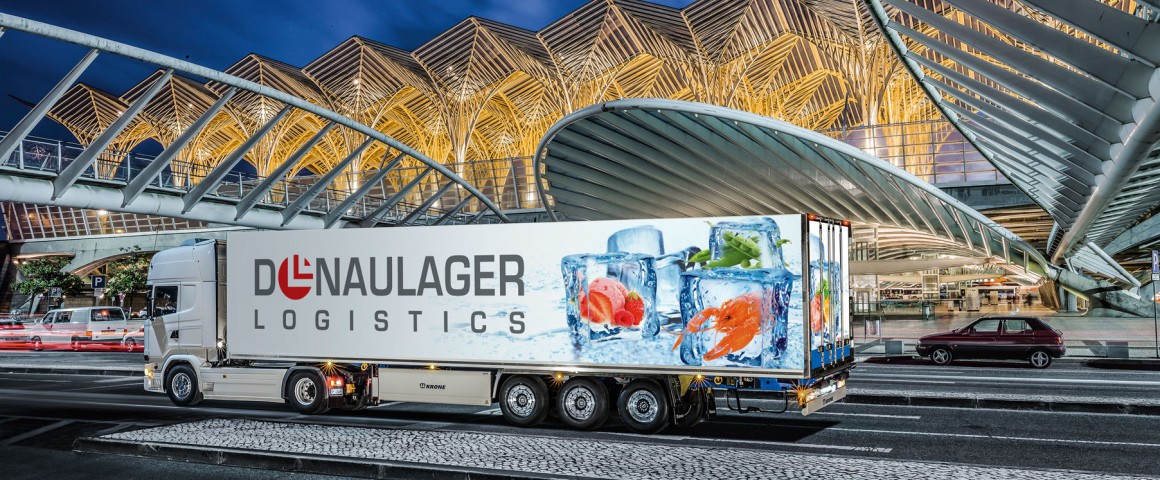 LKW mit Donaulager-Branding vor modernem Gebäude