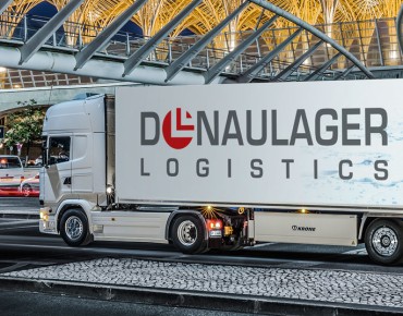 LKW mit Donaulager-Branding vor modernem Gebäude