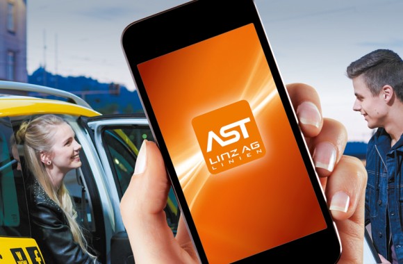 Ein Handy mit der AST-App wird vor eine, sich unterhaltende Menschenmenge gehalten.