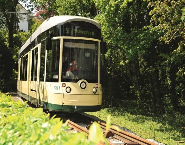 Die fahrende Pöstlingbergbahn in der Natur.