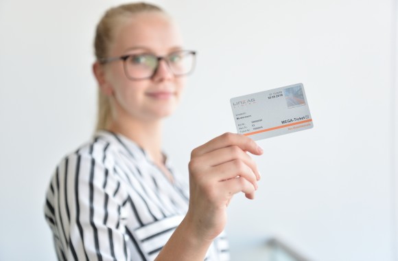 Eine Frau hält das LINZ AG Linien Mega-Ticket in der Hand.