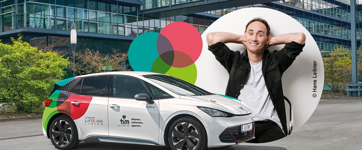 Linz AG: Ein Mann lehnt entspannt am Auto der Linz AG in Linz.