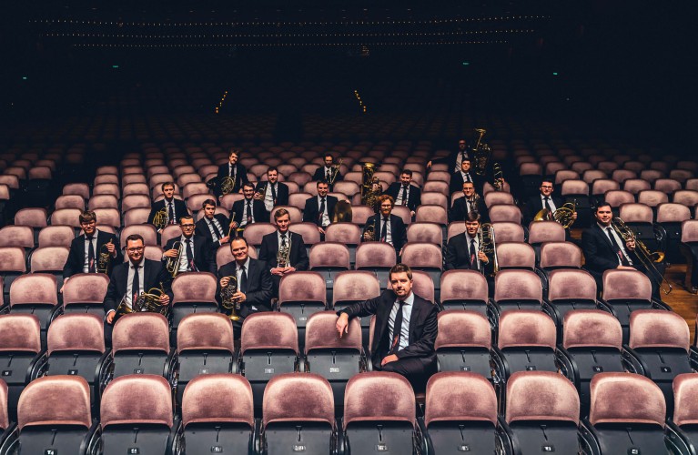 Musiker in dunklen Anzügen (Vienna Brass Connection) sitzen in den Zuschauerreihen eines Theaters. Copyright: Light HuntersPhotography