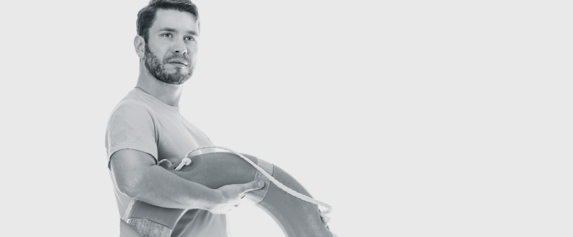 Schwarz-Weiß-Bild von Mann mit Schwimmreifen in der Hand