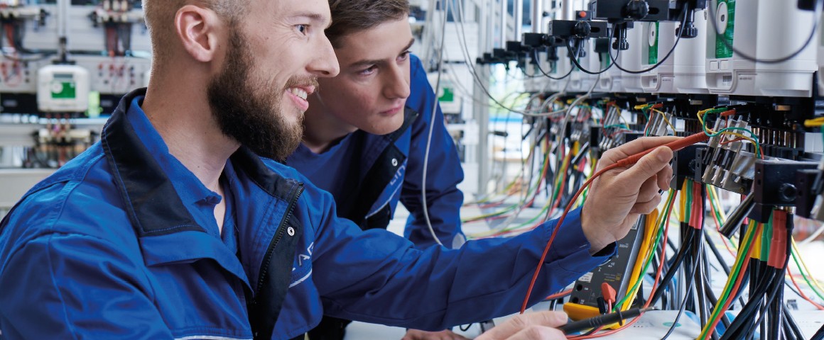 Elektroniker mit Lehrling bei der Arbeit