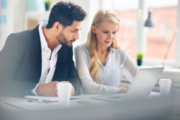 ein Herr und eine Dame sitzen gemeinsam vor einem Laptop