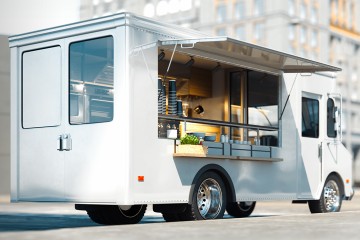 Foodtruck vor einem Bürogebäude mit aufgeklappter Front