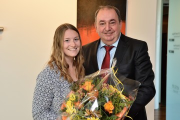 Mitarbeiterin Nadine Altmann bekommt von Generaldirektor Erich Haider einen Blumenstrauß überreicht. Sie hat erfolgreich an den Berufsweltmeisterschaften den WorldSkills teilgenommen.