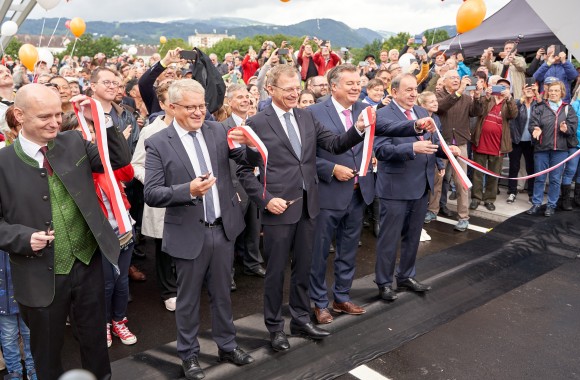 DI Erich Haider mit Bürgermeister und vielen weitern Menschen auf der neuen Eisenbahnbrücke.