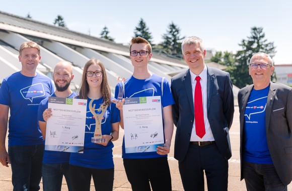 Vorstandsdirektor Josef Siligan mit zwei Mitarbeitern und zwei Lehrlingen, welche eine Auszeichnung und einen Pokal halten