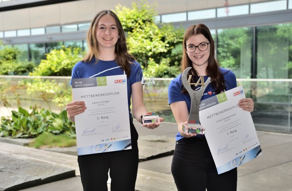 zwei weibliche Lehrlinge der Linz AG mit Auszeichnung und Pokal in den Händen lächeln freundlich in die Kamera