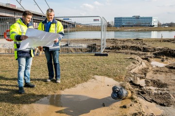 Herr Scharinger und Herr Ziegler, zwei Mitarbeiter der LINZ AG mit Plan vor einer Baustelle