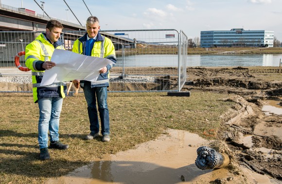 Herr Scharinger und Herr Ziegler, zwei Mitarbeiter der LINZ AG mit Plan vor einer Baustelle