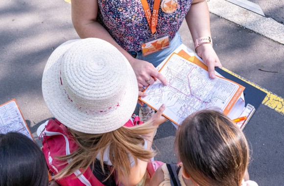 Frau erklärt Kindern den Stadtfahrplan der LINZ AG LINIEN