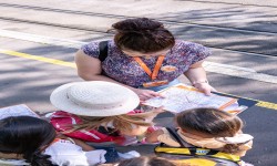 Frau erklärt Kindern den Stadtfahrplan der LINZ AG LINIEN