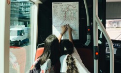 Kinder in Bus der LINZ AG LINIEN betrachten einen Liniennetzplan.