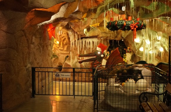 Bild von Drache Lenzibald in der Grottenbahn, welche Weihnachtlich dekoriert ist.