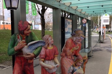 Figuren der Grottenbahn beim Warten bei einer Bushaltestelle in Linz