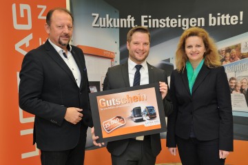 Philipp Köstenberger hält den MEGA-Ticket-Gutschein in den Händen, daneben stehen der Vetriebsleiter der LINZ AG LINIEN und die LINZ AG-Vorstandsdirektorin Dr.in Jutta Rinner.